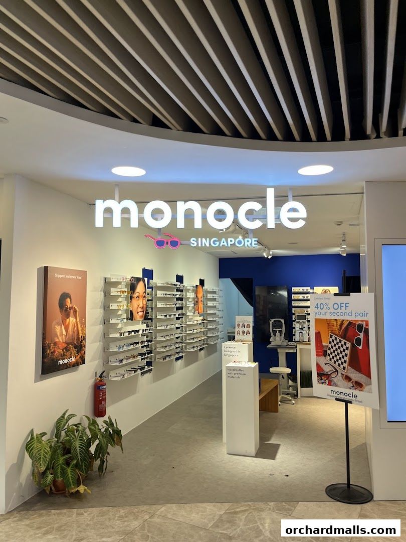 The Monocle Singapore eyewear shop entrance with displays of glasses and a promotional sign.