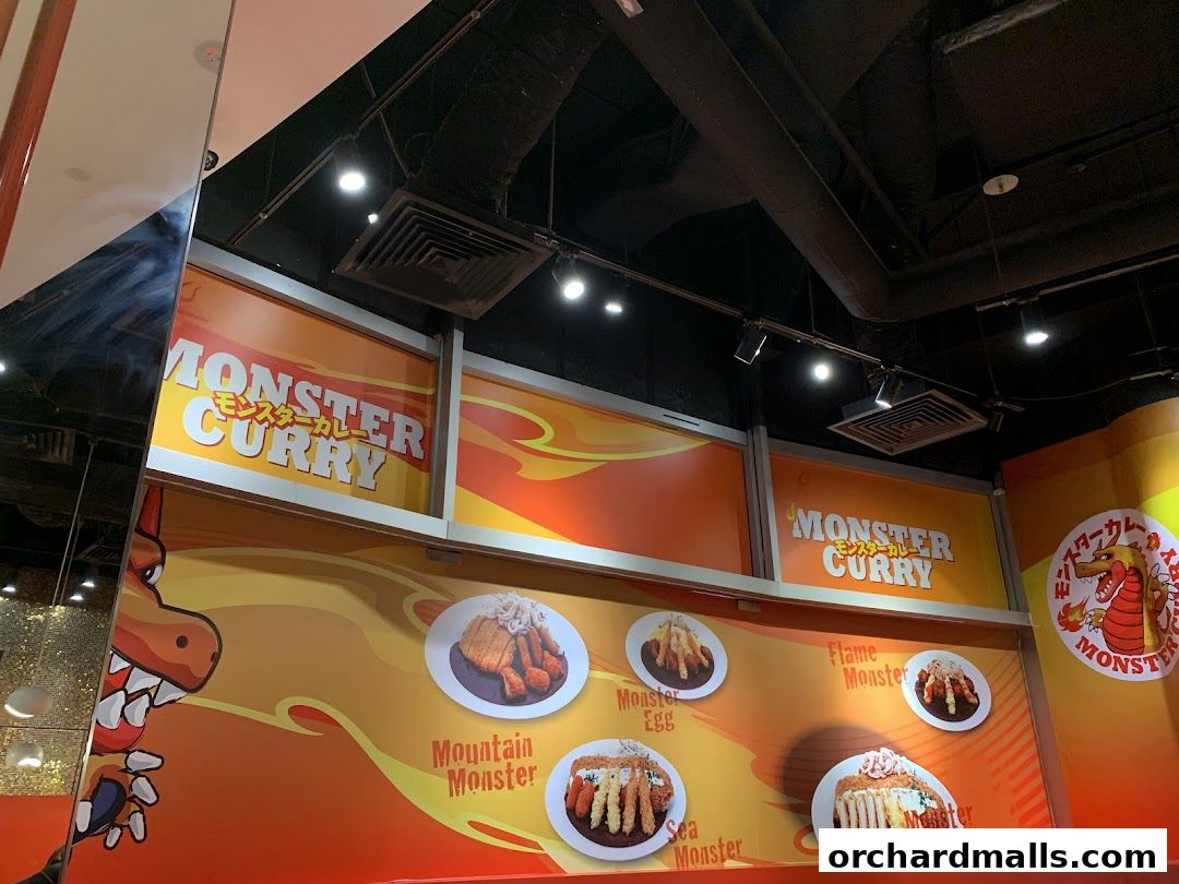 Interior view of Monster Curry restaurant with menu item photos and branding.