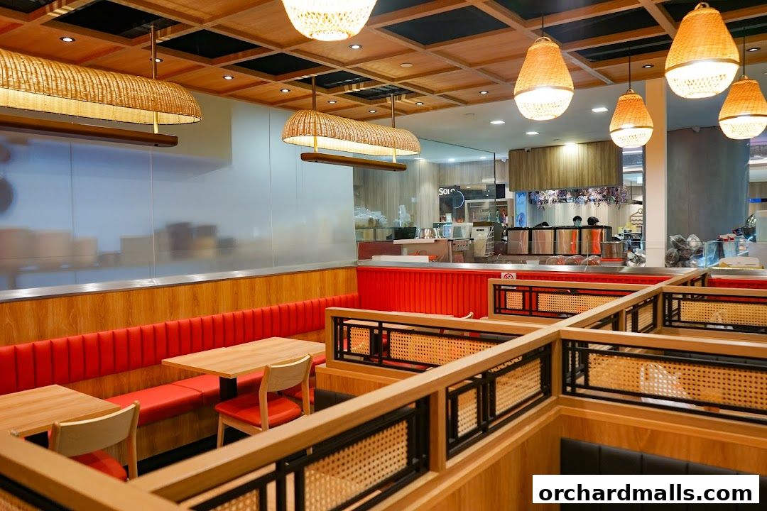 Interior view of a restaurant with wooden tables, red seating, and rattan light fixtures.