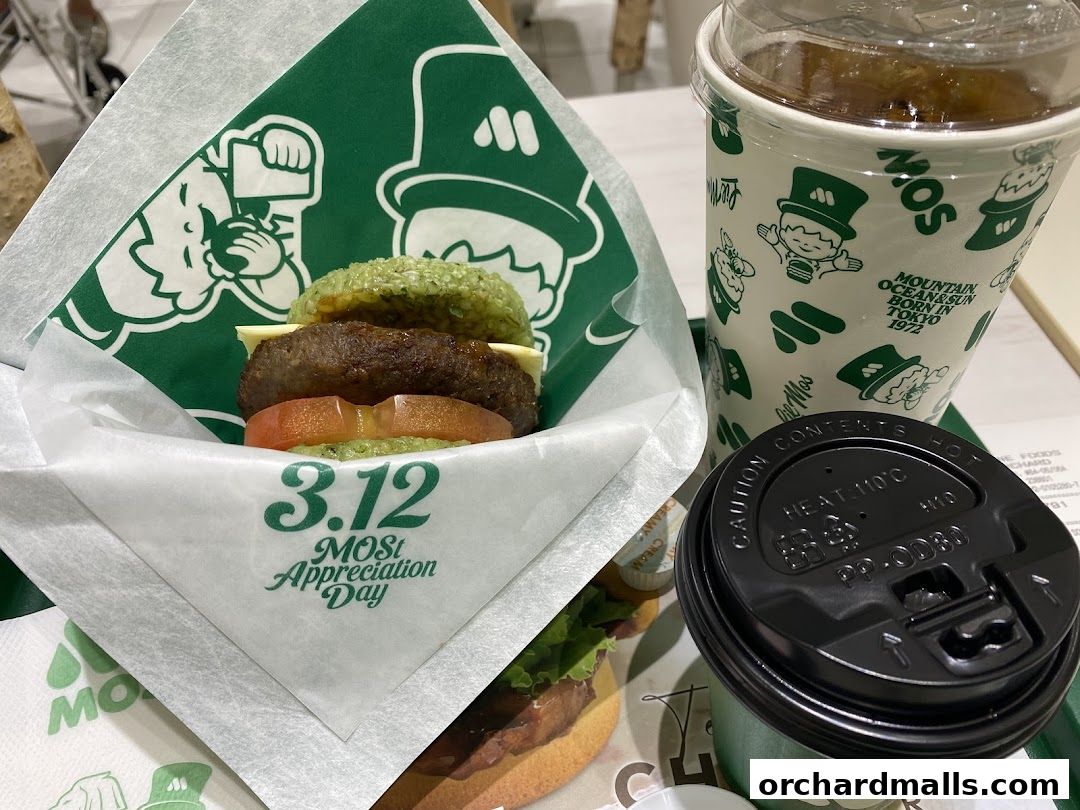 A MOS Burger meal featuring a burger, drink, and coffee cup with branded packaging.