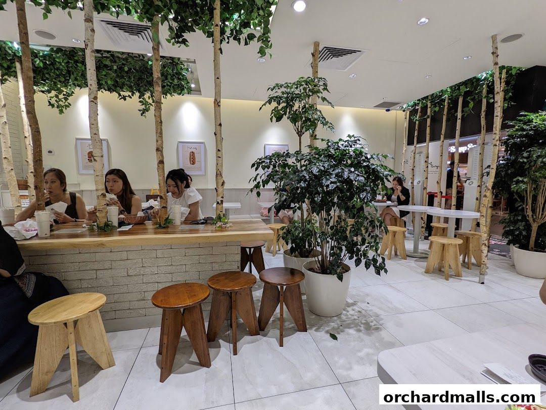 People dining at a MOS Burger restaurant with a natural, birch tree-themed interior.