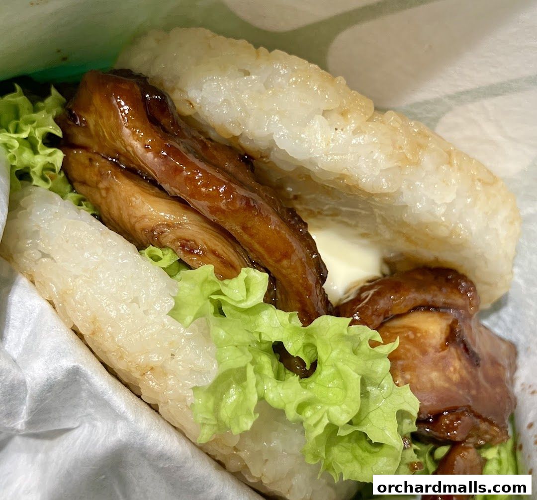A close-up of a delicious MOS Burger rice burger with grilled chicken and lettuce.