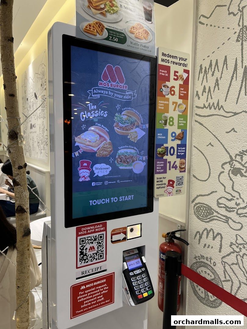 A MOS Burger self-order kiosk displaying menu items and rewards.