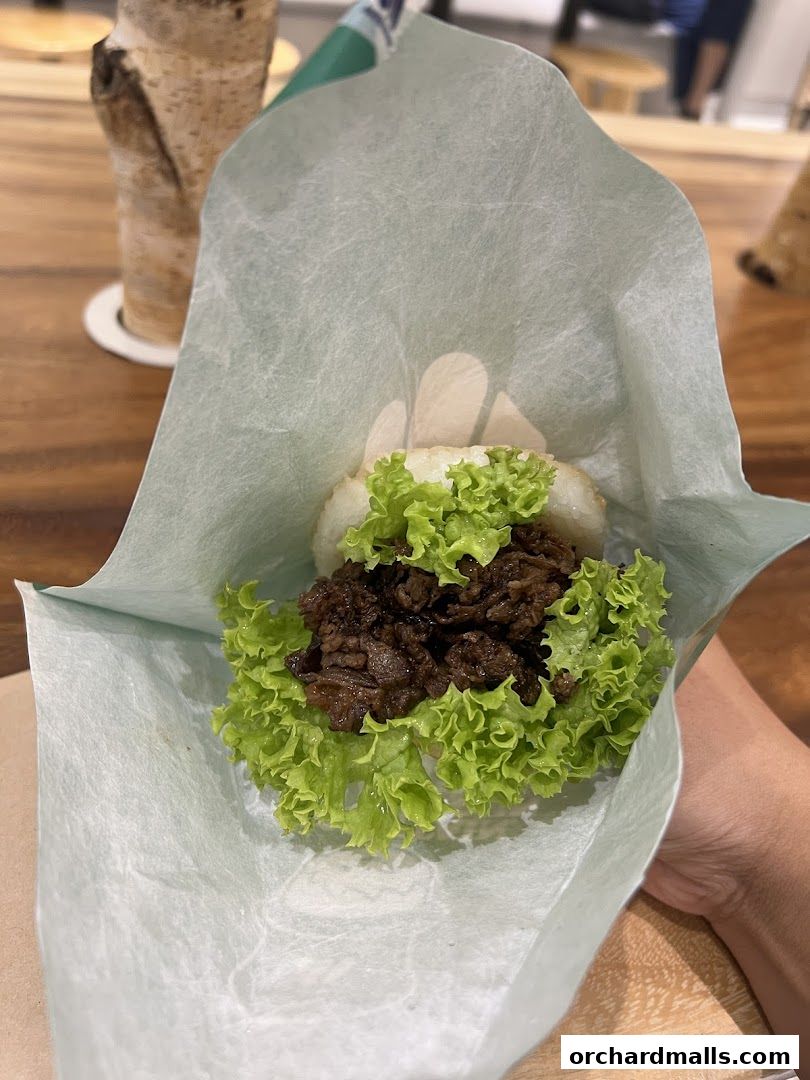 A close-up of a MOS Burger rice burger with lettuce and meat filling.