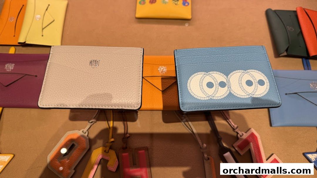 A display of colorful leather cardholders and decorative letter charms.