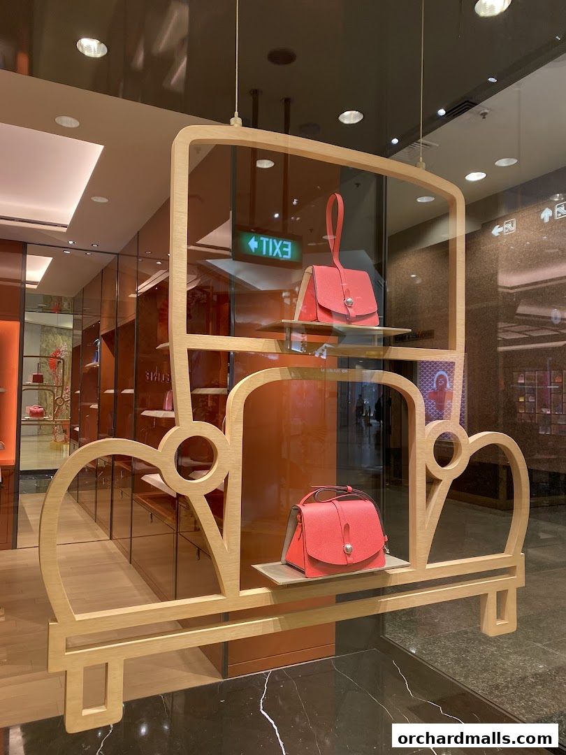 A stylish display window featuring elegant handbags in a car-themed wooden frame.