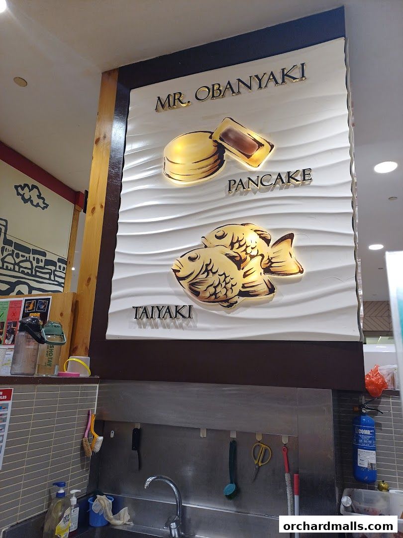 Signage for Mr. Obanyaki Taiyaki Japanese Pancakes featuring pancakes and fish shapes.