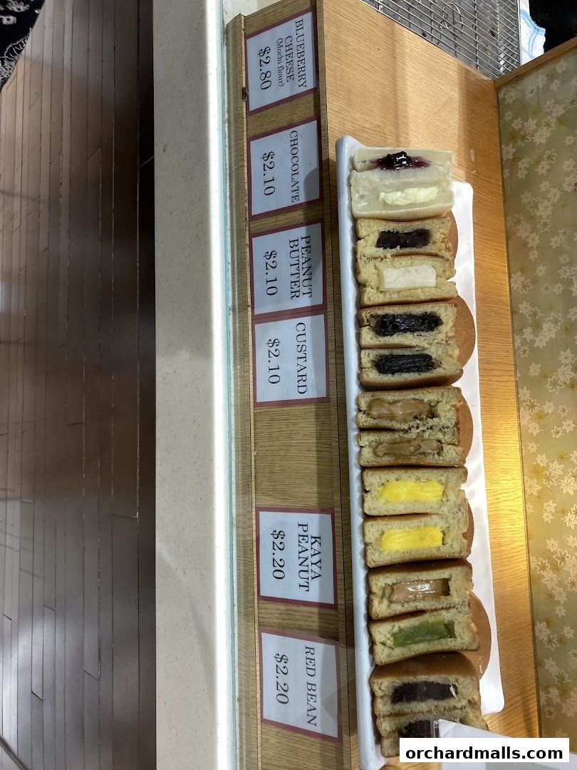 A display of various Japanese pancakes with different fillings and prices.