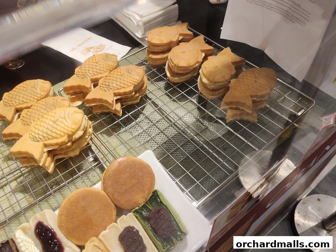 Freshly made Japanese fish-shaped pancakes (Taiyaki) and other sweet treats displayed.