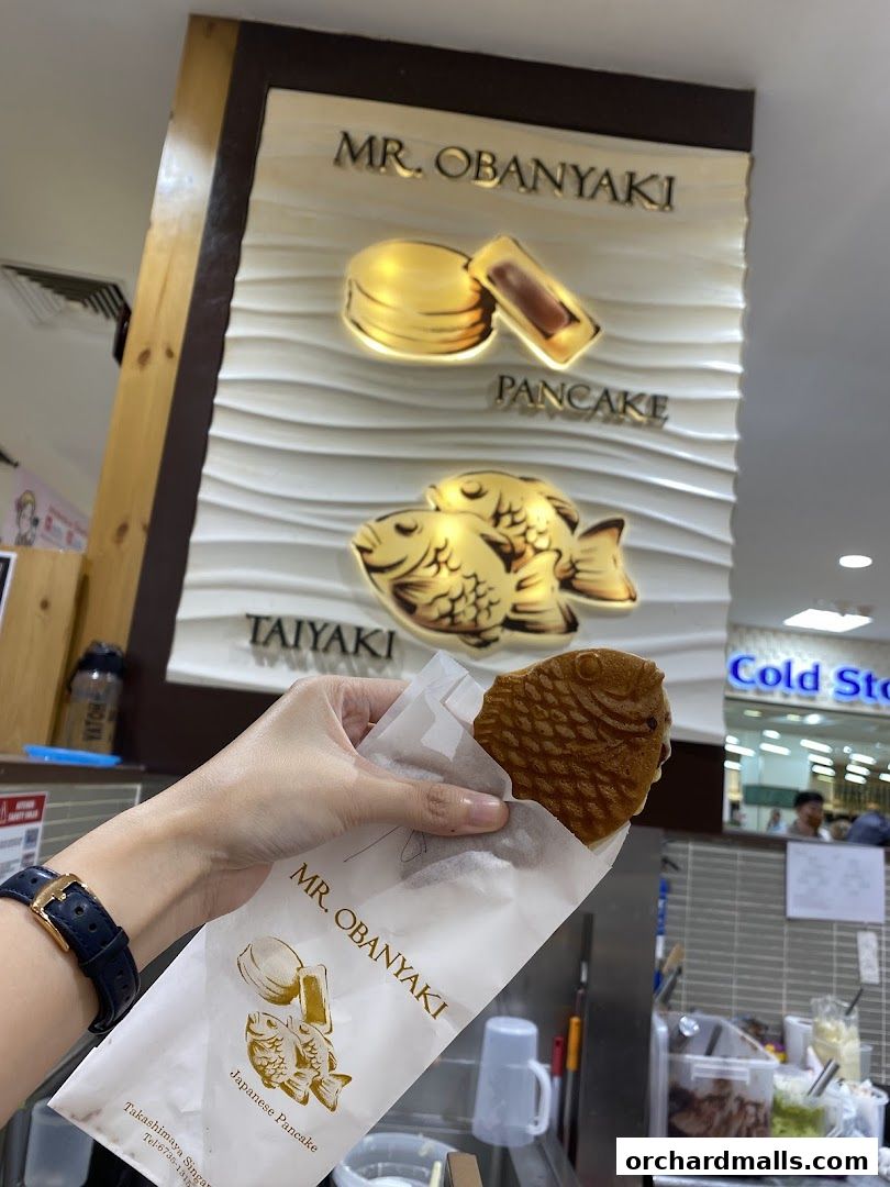 A hand holds a fish-shaped Japanese pancake from Mr. Obanyaki.