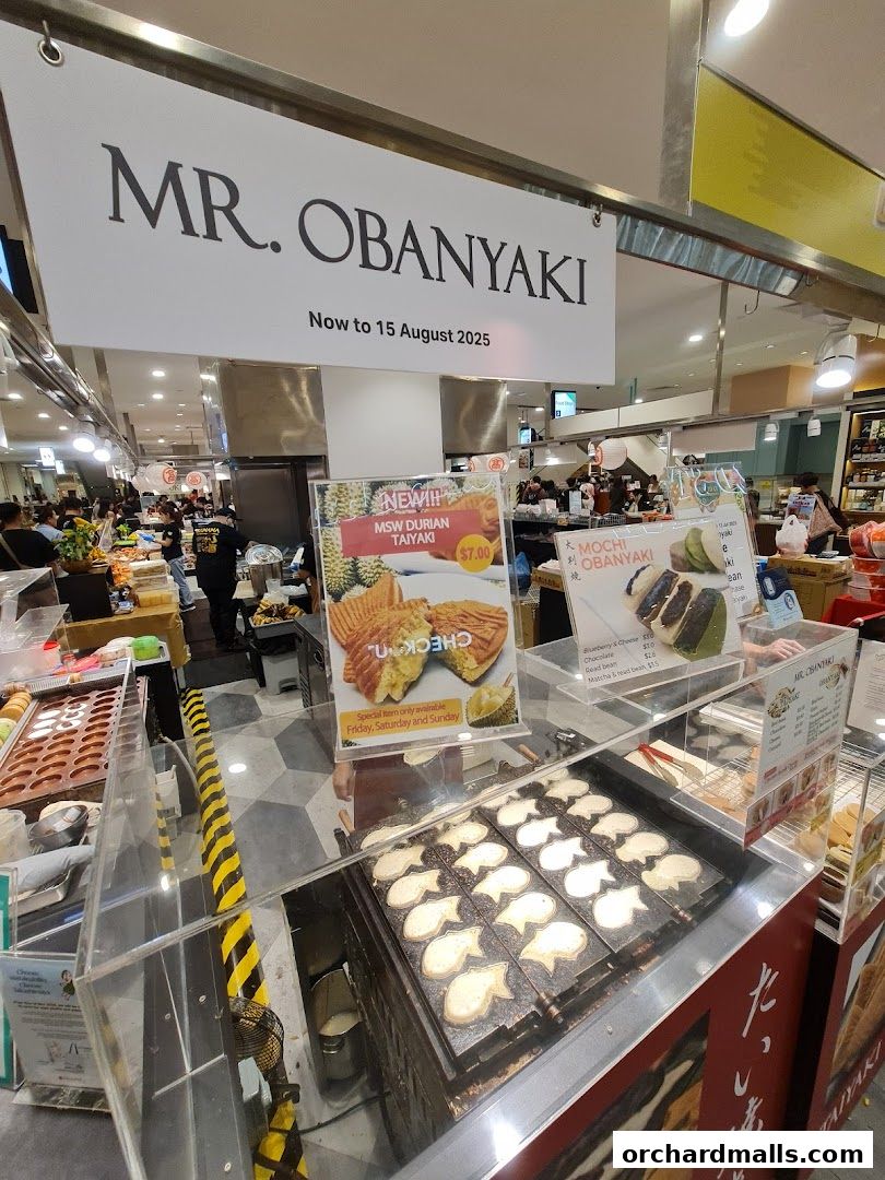 Mr. Obanyaki shop front with taiyaki cooking and promotional signs.