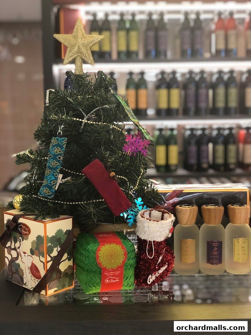 Christmas display with a tree, gift boxes, and perfume bottles from Mt. Sapola.