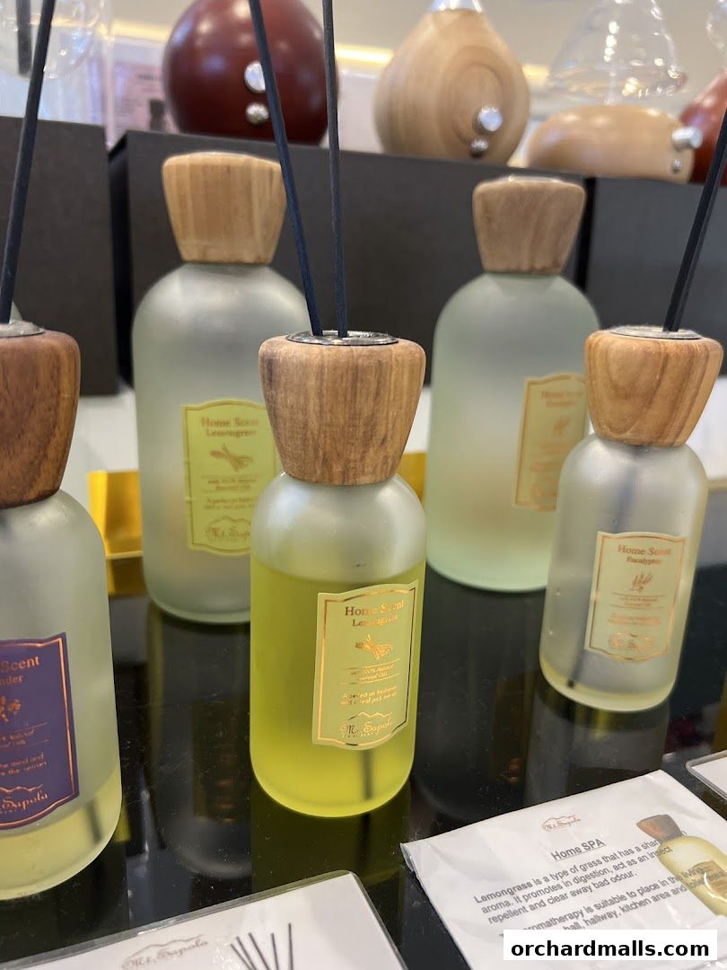 A display of various home scent diffuser bottles with wooden caps and reeds.