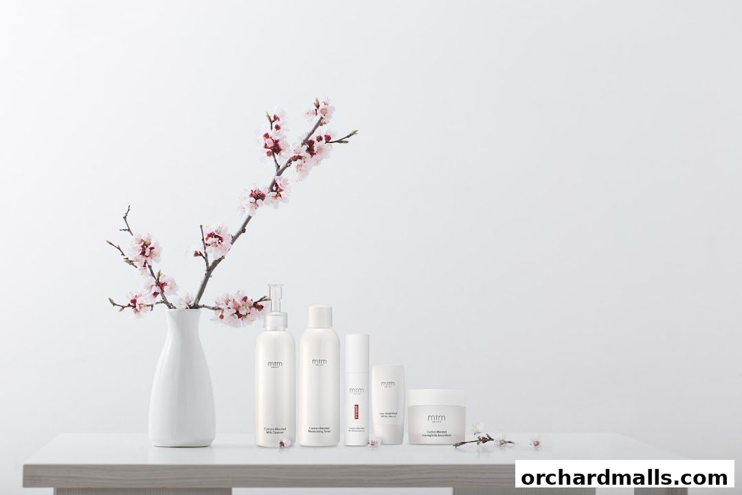 Skincare products displayed with a vase of blooming cherry blossoms.