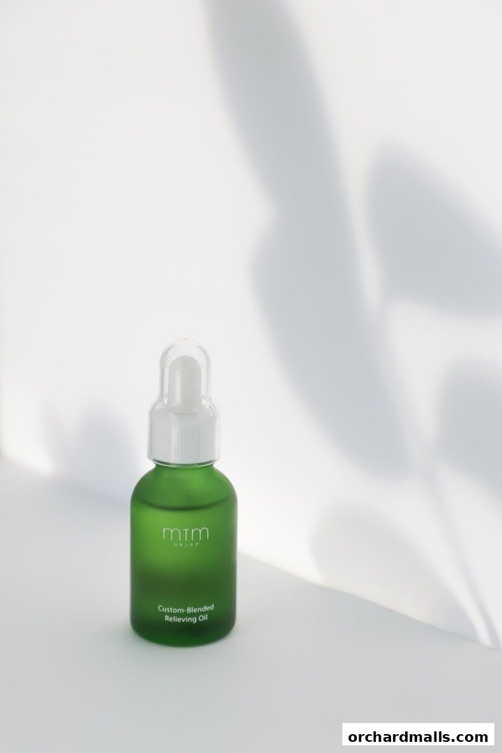 A green bottle of mtm labo Custom-Blended Relieving Oil with soft shadows.