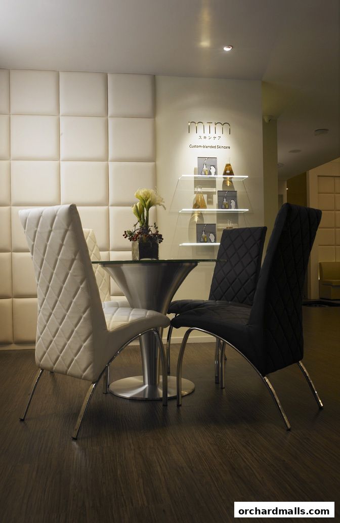 Interior of a skincare shop with plush chairs and display shelves.