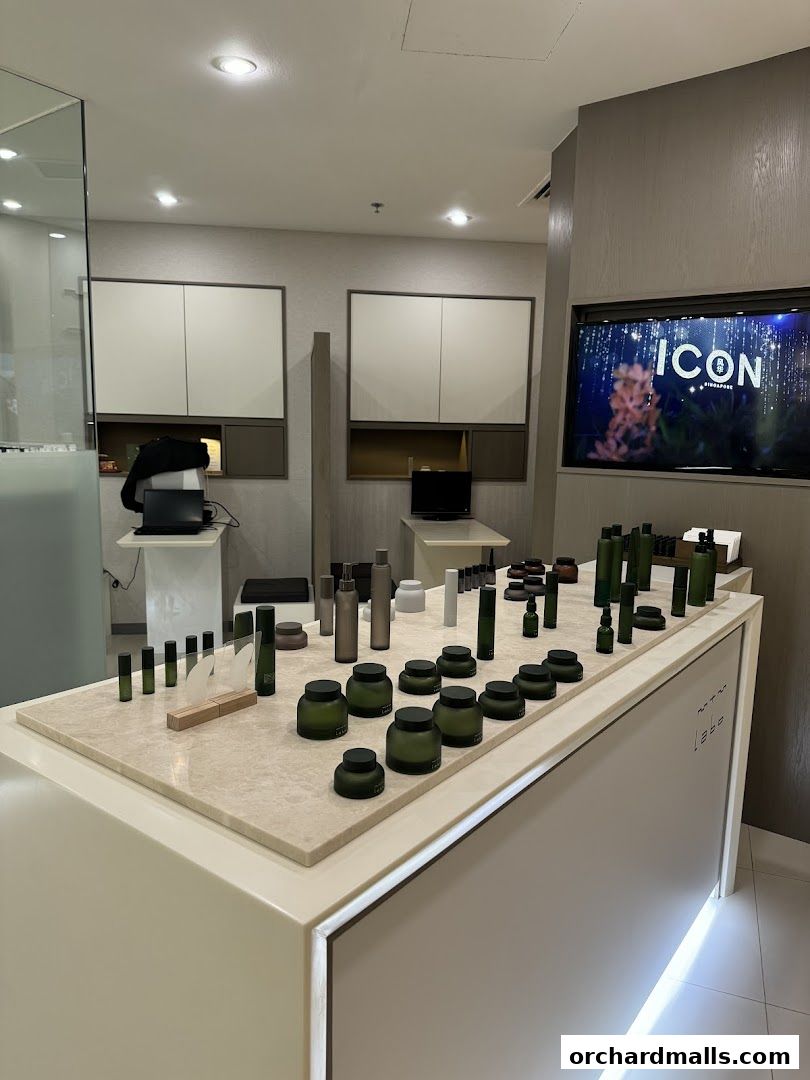 A display of skincare products with elegant green bottles and jars on a marble countertop.