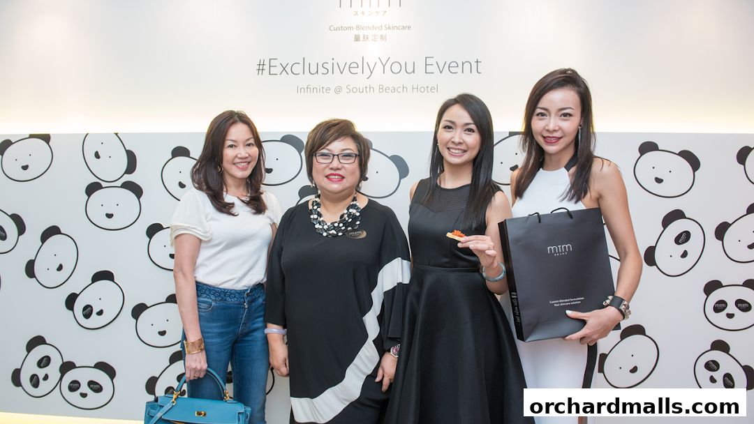 Four women pose for a photo at an event with a panda-themed backdrop.
