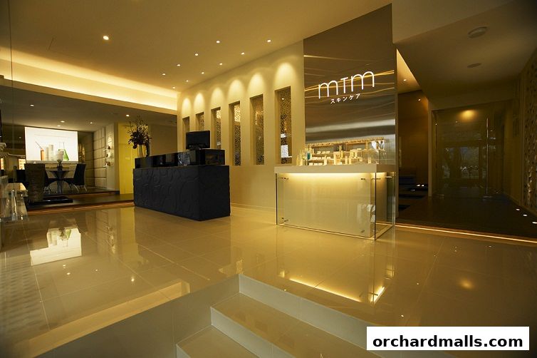 Interior view of a modern skincare clinic with a reception desk and product displays.