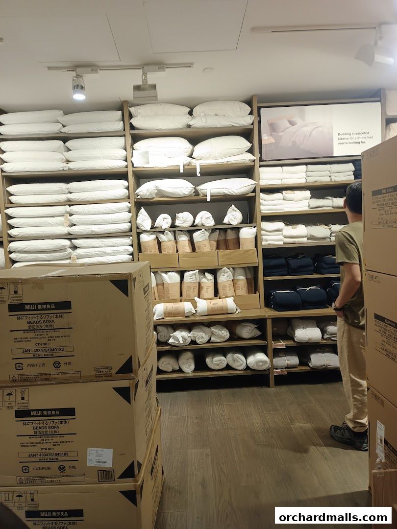 Interior shot of MUJI showing shelves stocked with pillows, bedding, and boxed items.