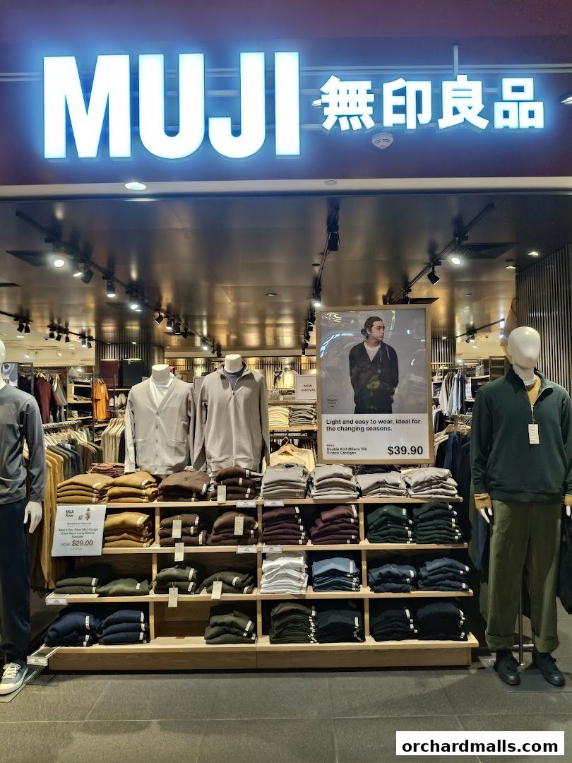 MUJI store interior showcasing folded sweaters and mannequins wearing casual apparel.
