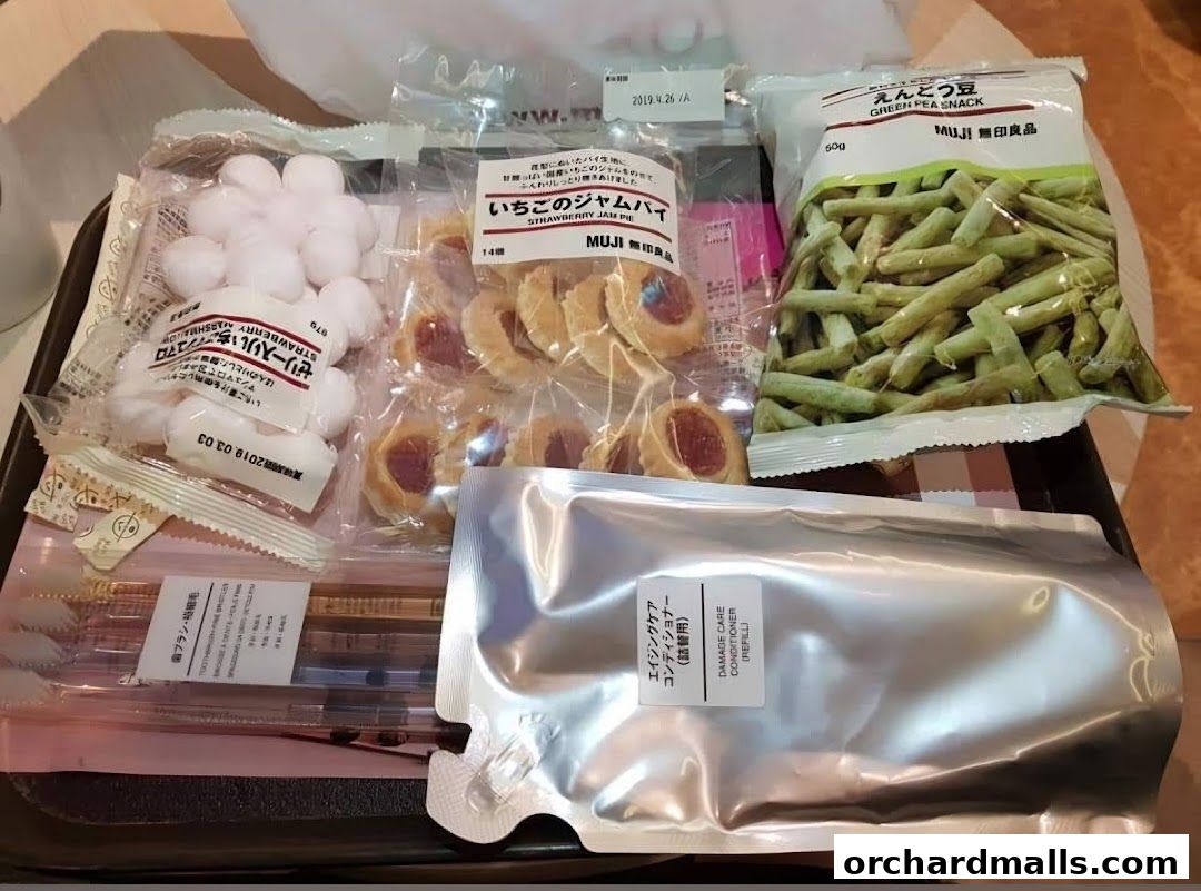 A tray filled with various MUJI products including snacks, toiletries, and a conditioner refill.