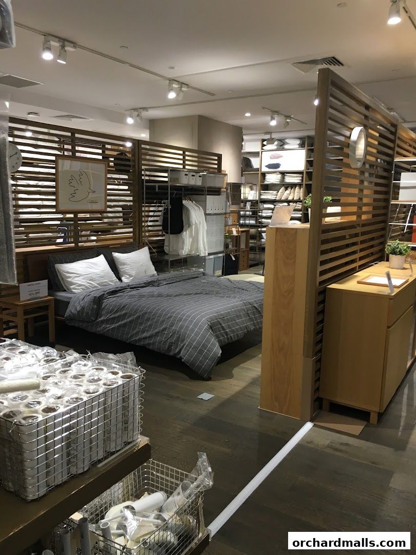 Interior view of a MUJI store showcasing a bedroom setup and various home goods.