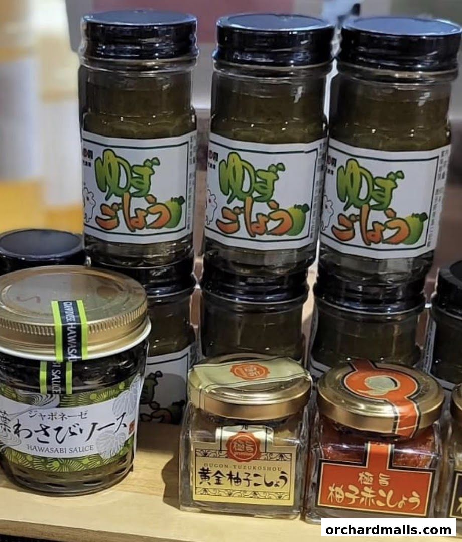 A selection of Japanese sauces and condiments in glass jars, including wasabi sauce and yuzu pepper.