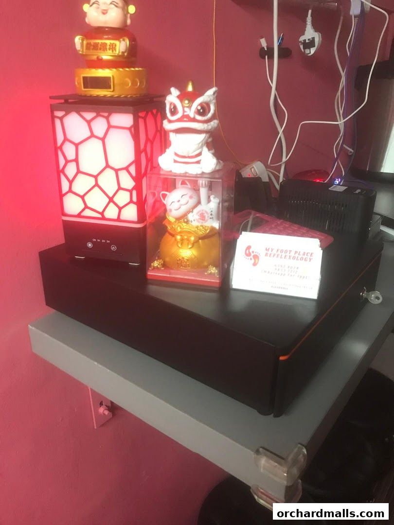 A desk with decorative items and a business card for My Foot Place Reflexology.