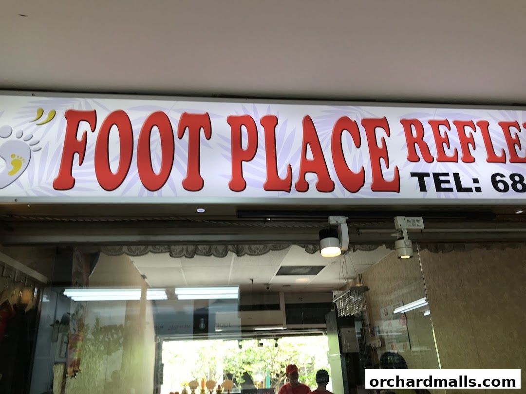 The illuminated sign for 'My Foot Place Reflexology' with a phone number.