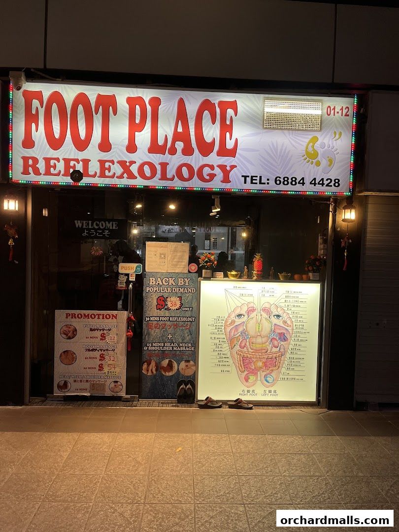 Shop front of 'My Foot Place Reflexology' with promotions and a reflexology chart.