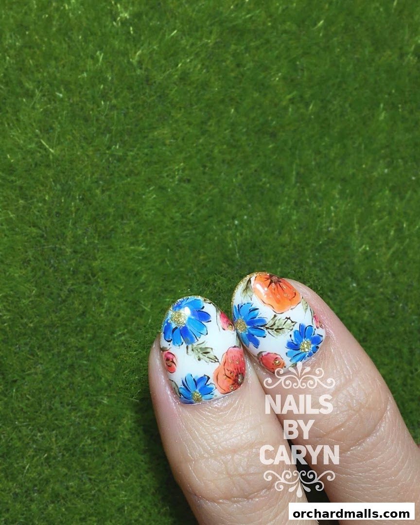 Close-up of nails with floral art and the shop name 'Nails by Caryn'.