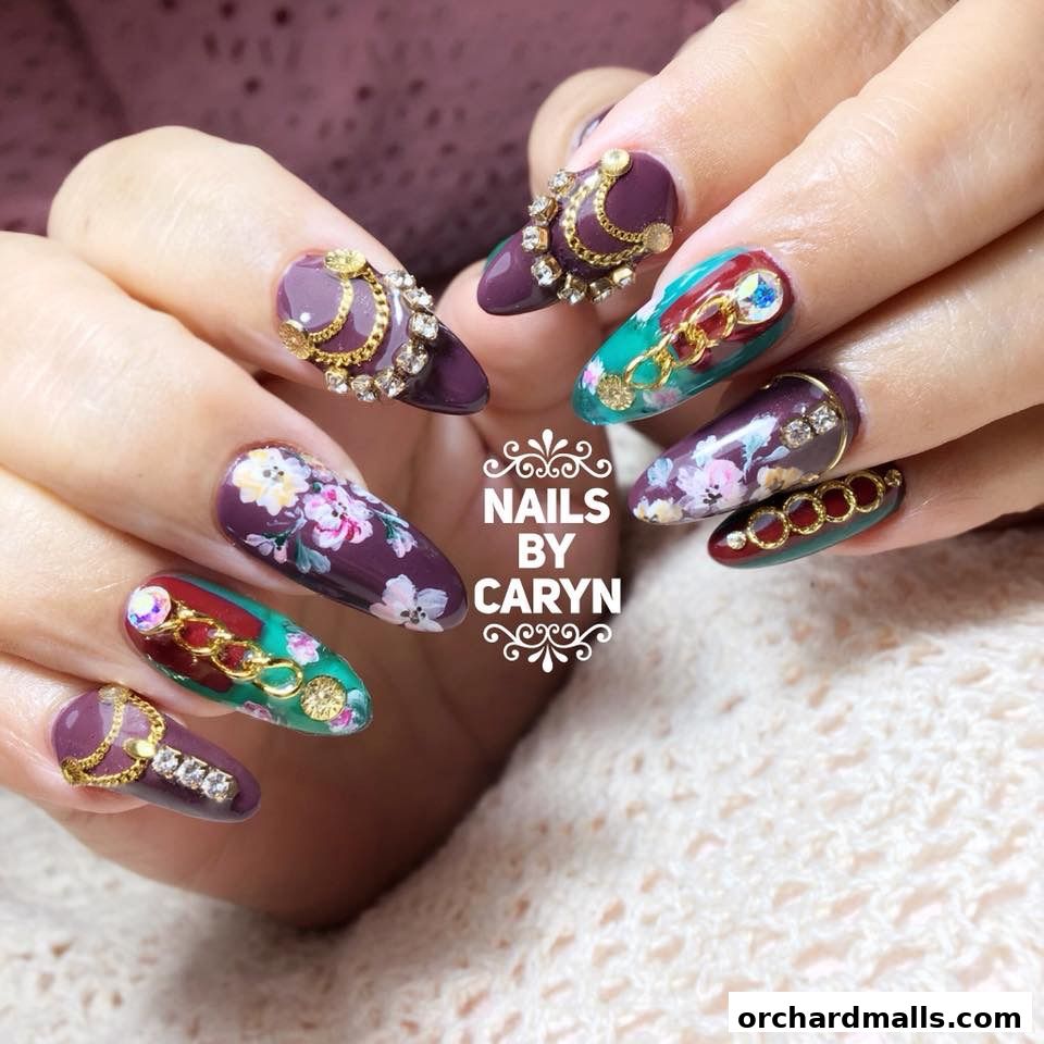 Close-up of hands with elaborately decorated nails featuring floral and jewel designs.