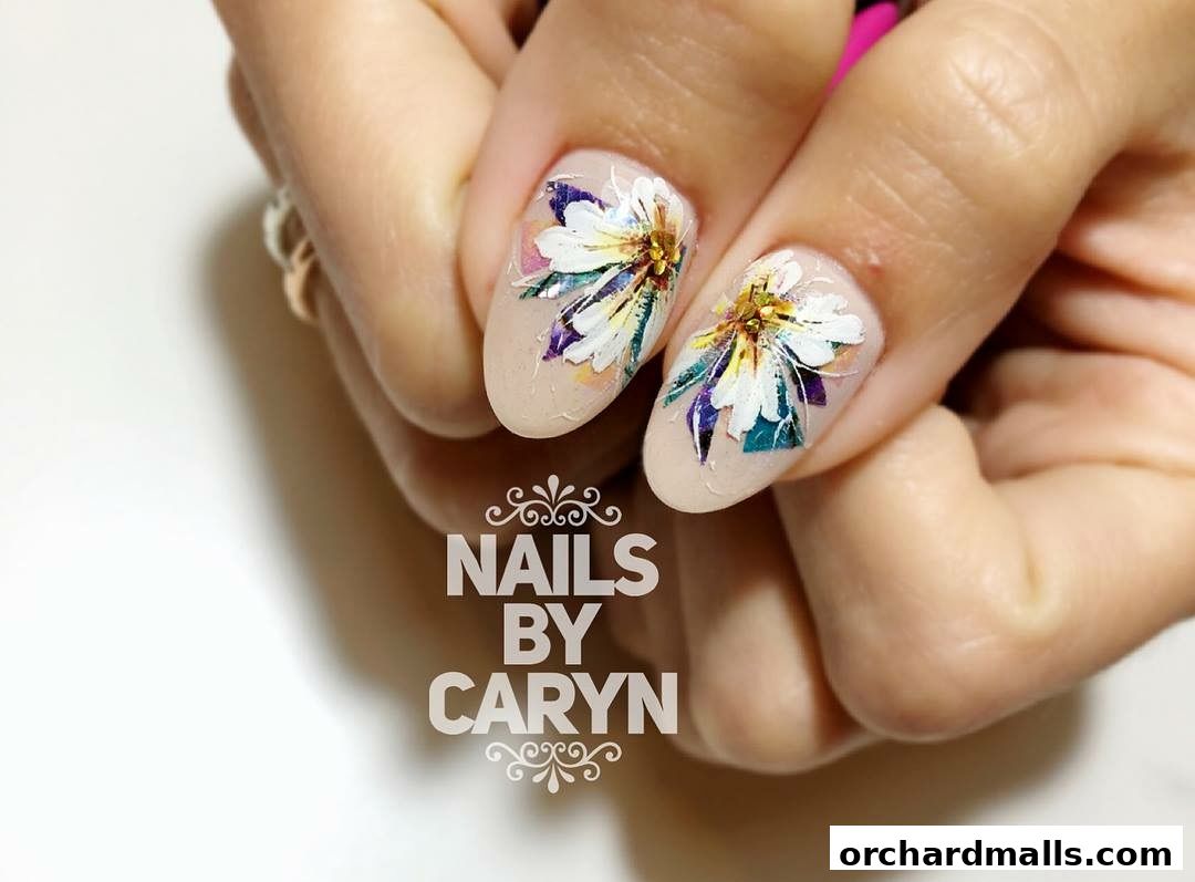 Close-up of a hand with beautifully decorated nails featuring floral designs.