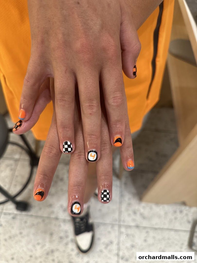A close-up of hands with creative nail art featuring checkered flags and racing-inspired designs.