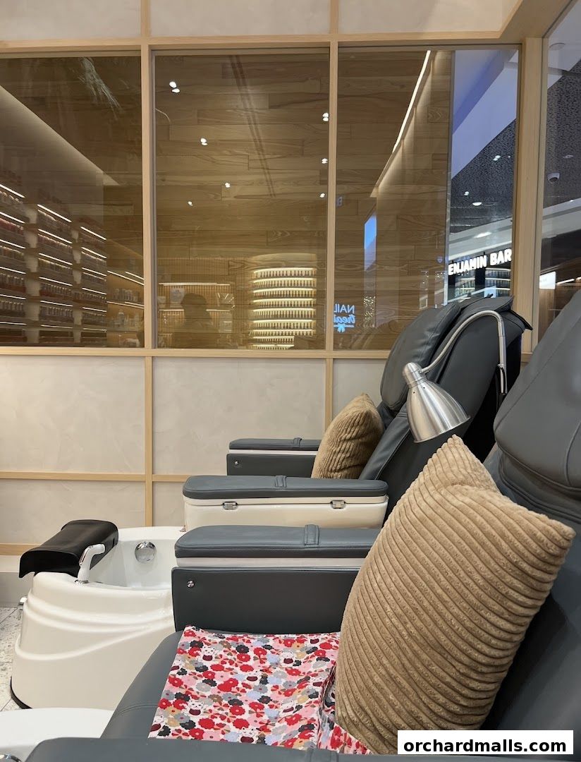 Comfortable pedicure chairs and foot baths inside a modern nail salon.