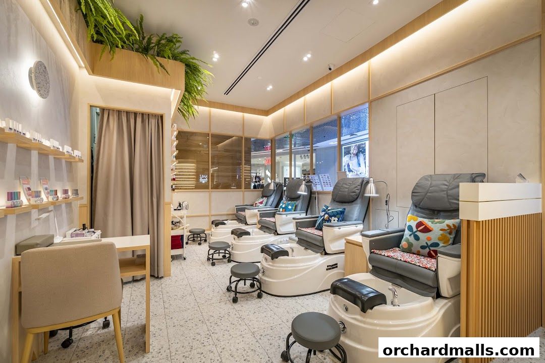 Interior of a modern nail salon with comfortable pedicure chairs and shelves stocked with nail polish.