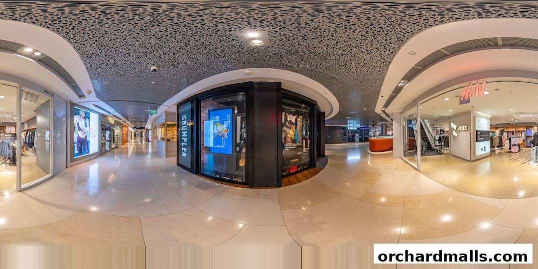 A panoramic view of a shopping mall corridor with various stores, including H&M and Crumpler.