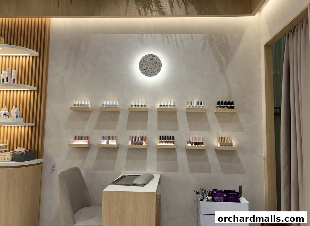 Interior of a nail salon with shelves displaying nail polish bottles and a manicure station.