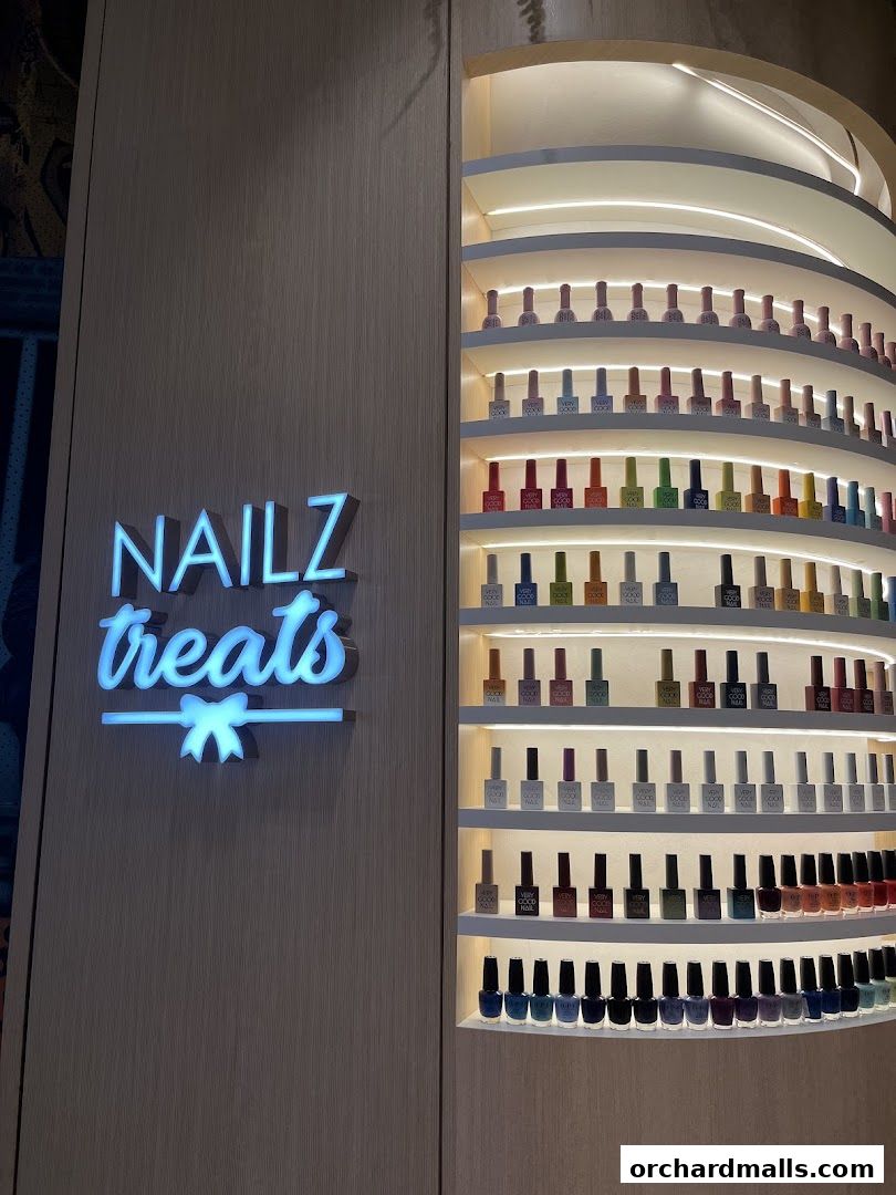 A brightly lit display shelf showcasing a wide variety of nail polish colors at Nailz Treats.