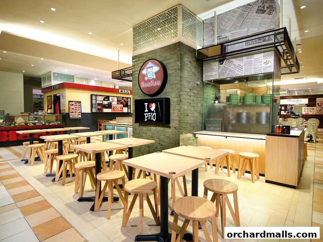 Interior view of NamNam Noodle House with tables, chairs, and a food counter.