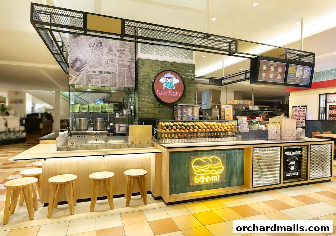 A modern food stall with a display of banh mi and seating area.