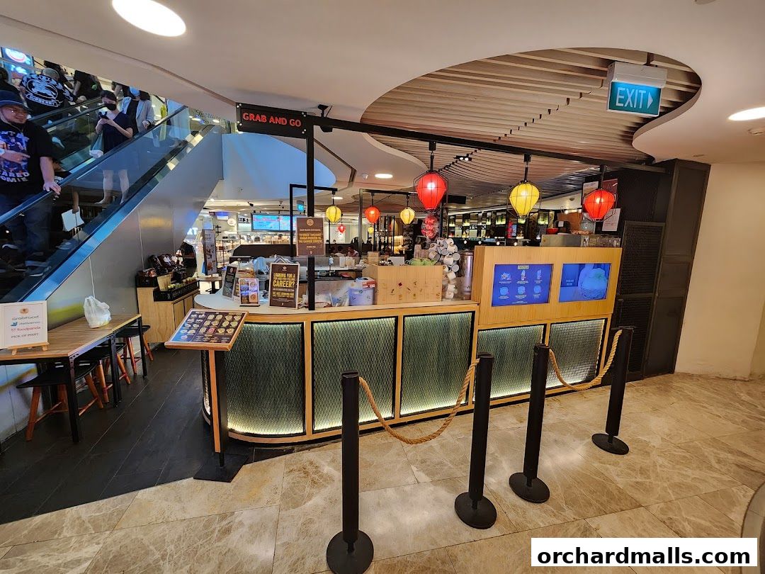A grab-and-go food counter with digital menus and seating area.