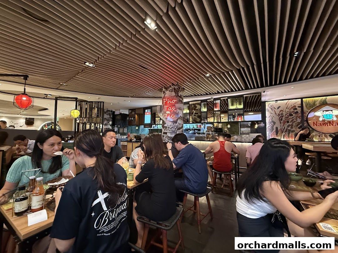 Diners enjoy meals inside NamNam Wheelock Place, a Vietnamese restaurant with modern decor.