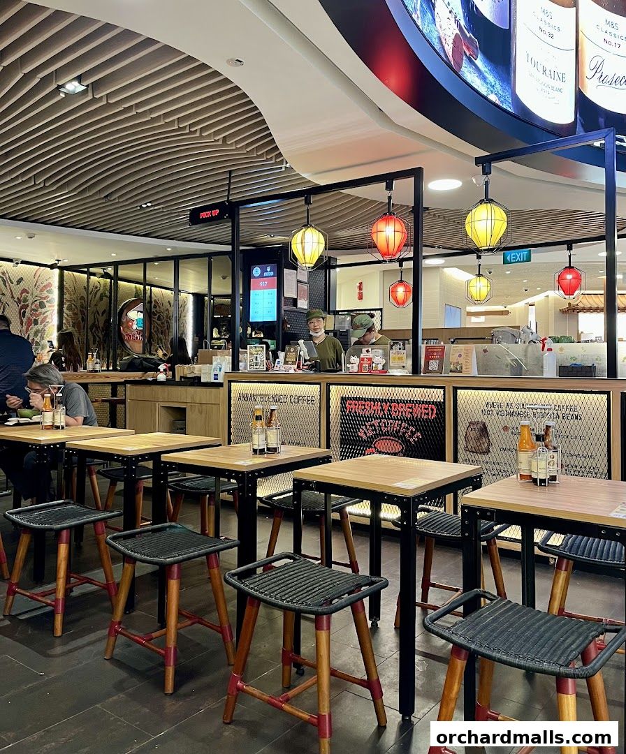 Interior of NamNam Wheelock Place with tables, chairs, and counter staff.