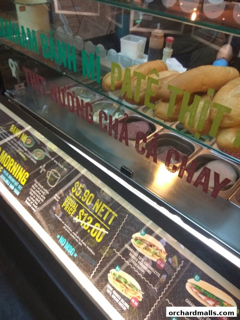 A display case showing various banh mi options with prices and ingredients.