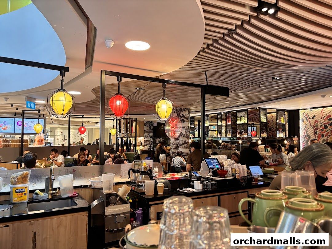 Interior of a busy Vietnamese restaurant with customers dining and staff serving.