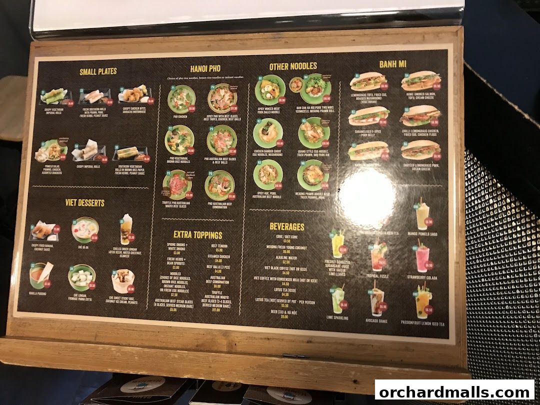 A menu board displaying Vietnamese dishes, including pho, banh mi, small plates, desserts, and beverages.
