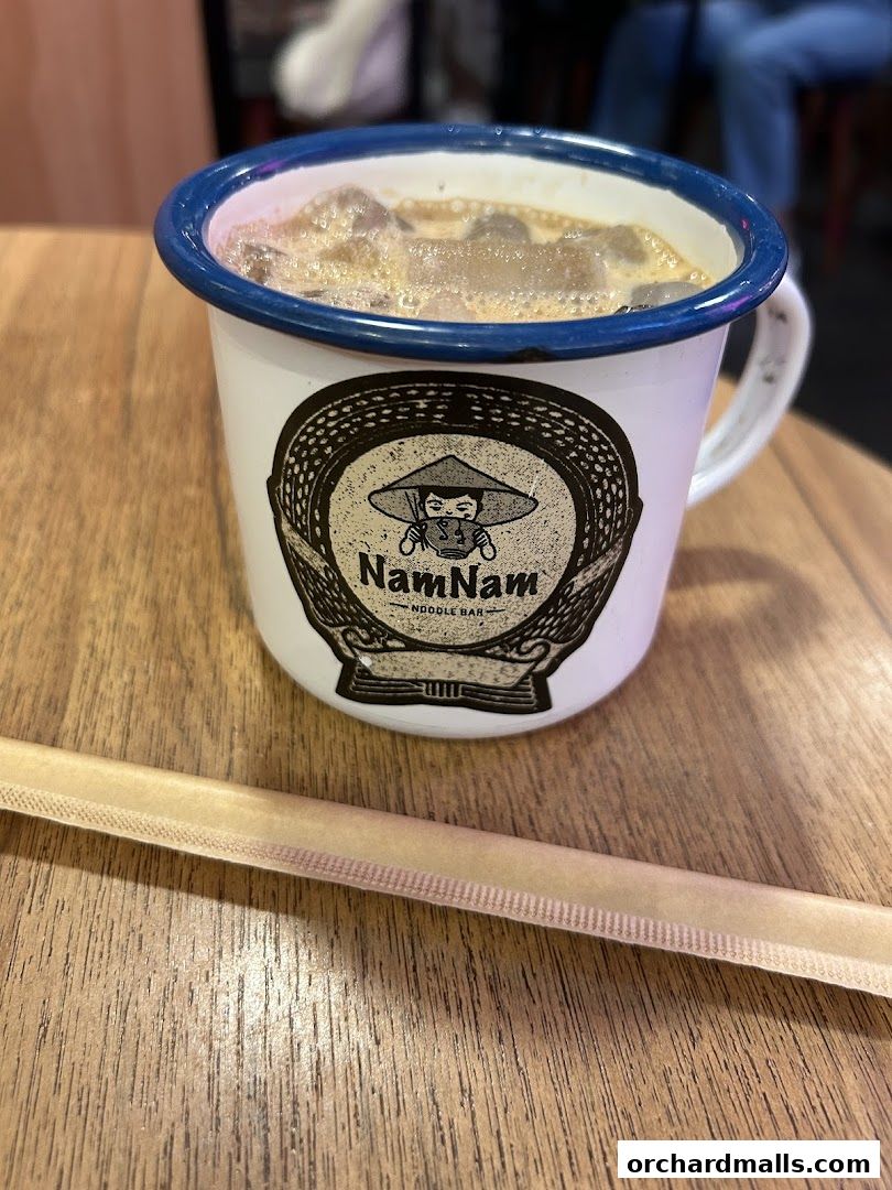 A refreshing iced drink in a branded mug from NamNam Noodle Bar.