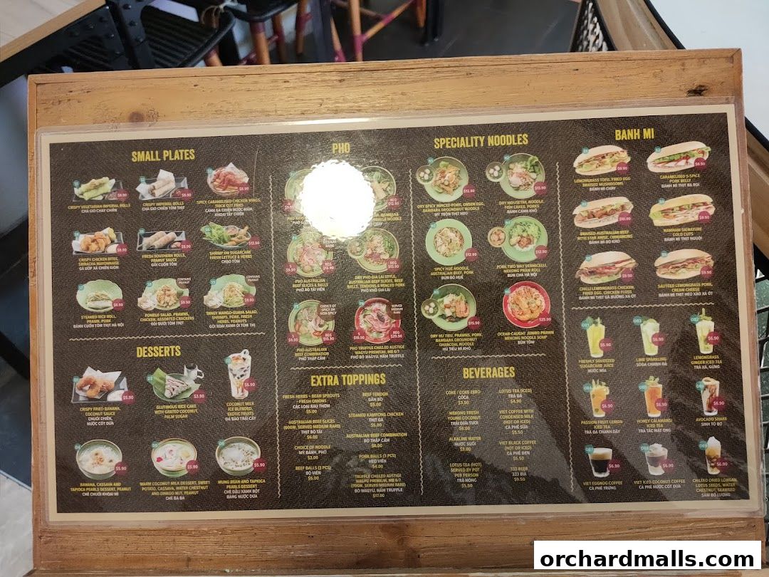 A menu board displaying Vietnamese dishes like Pho, Banh Mi, and desserts with prices.
